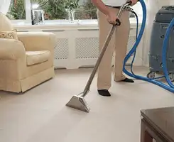 Carpet cleaning professional removing dirt and stains with a hot-water extraction tool in a home, Tallahassee, FL.
