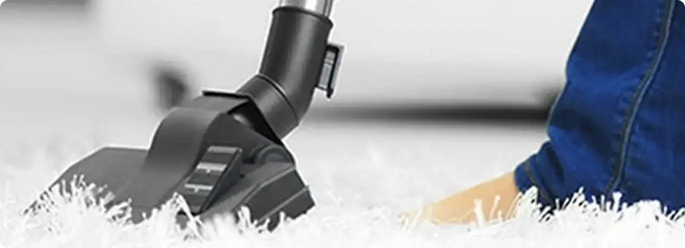 Close-up of a professional vacuuming a white carpet in Quincy.